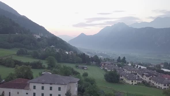 Aerial view of Levico Terme, Italy , during sunrise with drone rising.