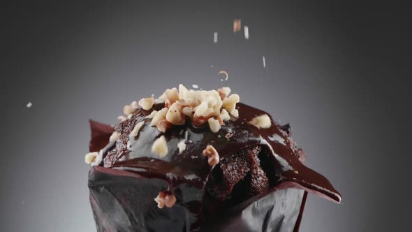 The grated nuts are poured on top of the chocolate covered muffin.