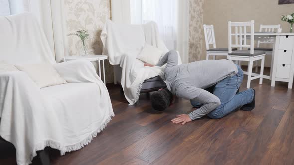 Man Looking for Something Under the Chairs