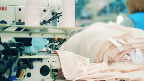 Pieces of Clothes Are Getting Sewn By the Factory Machine