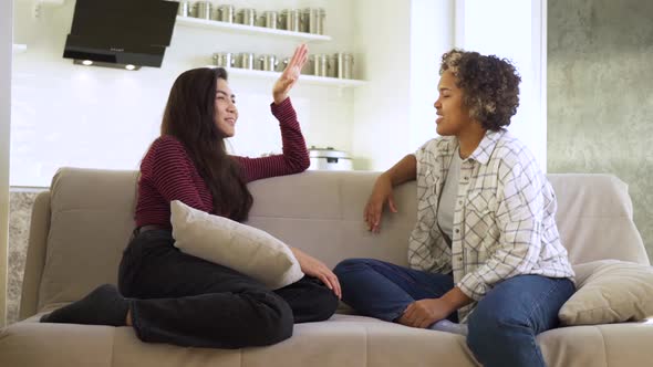 Slow Motion Two Girlfriends an AfricanAmerican and an Asian Chatting with Each Other While Sitting