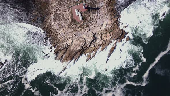 Top-down aerial of rocky outcrop in atlantic, with Doringbaai lighthouse