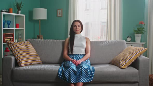 Portrait of Young Woman Sitting On Sofa