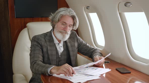 Busy Overworked Bearded Mature Businessman Tired From Working with Laptop and Paper Documents Takes