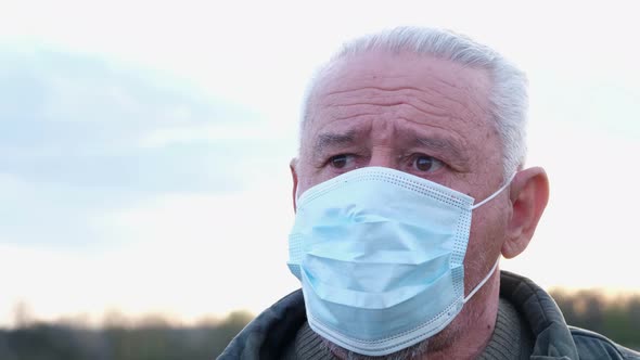 Worried Look of Grandfather in a Protective Medical Mask