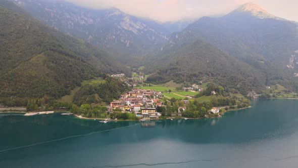 Aerial view of Ledro with lake, Trentino, Val di Ledro in North Italy. Front shot on the water in 4k