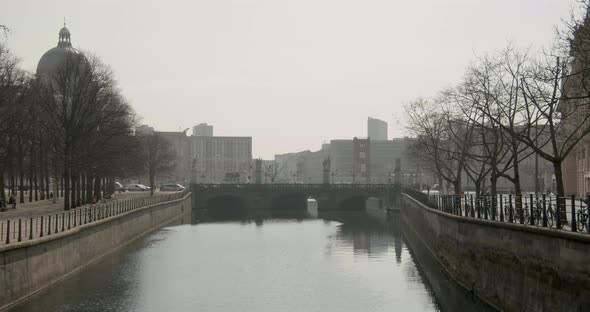 River Spree floats trough a bridge in Berlin with the City of Berlin in the background