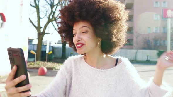 Young woman in the city having a video call on her smartphone