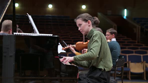 The pianist accompanies the string orchestra