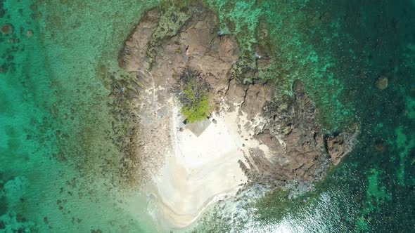 Aerial View of a Small Tropical Island on an Atoll with Beautiful Sandy Beach Surrounded By Coral