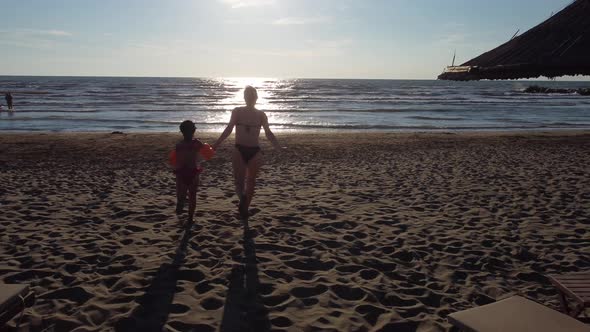 Mother and Daughter Walking on the Beach