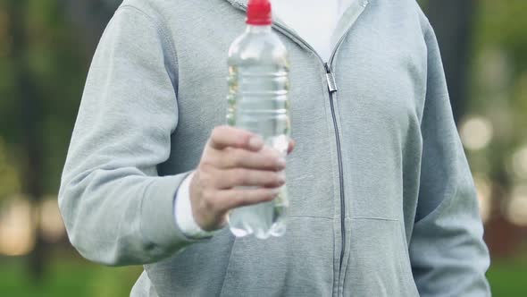 Sports Man Showing Thumbs-Up Holding Bottle With Beverage, Daily Water Intake