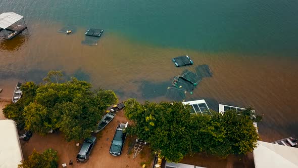 Bird's eye drone view flying over a fish farm on the shore of a lake in the Tocantins region of Braz