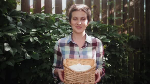 Portrait of Smiling Female Farmer Posing with Basket of Fresh Organic Chicken Eggs