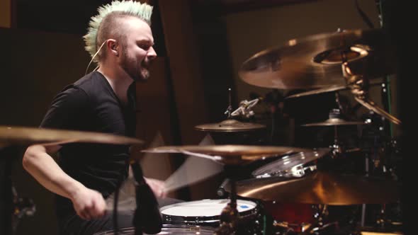 Hard rock drummer performing in a studio setting.