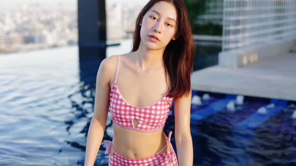 Asian young woman relax in swimming pool at luxury hotel
