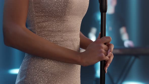 Female Hands on a Microphone Stand