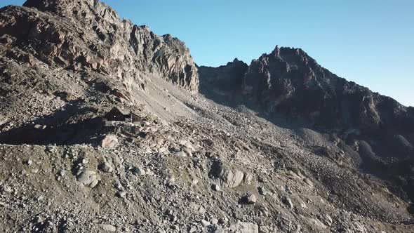 Orny cabin in the Swiss alps, high altitude rocky mountains and sunrise. aerial view by drone