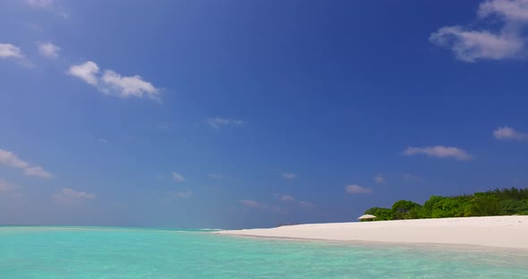 Tropical drone travel shot of a white paradise beach and blue water background in vibrant 4K