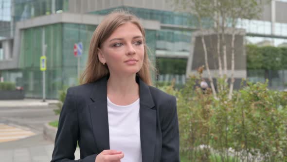 Serious Businesswoman Walking on the Street While Looking Around