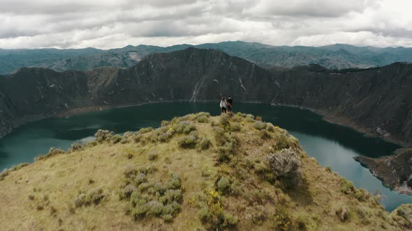 Drone Flyover Hikers On Top Of Quilotoa Loop Overlooking The Lagoon In Ecuador. Aerial Shot