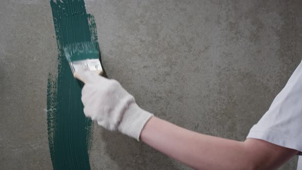 Renovation Painting Walls with Blue Paint Using Brush Closeup