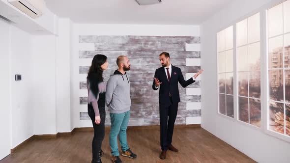 Successful Real Estate Agent Talking with Young Couple