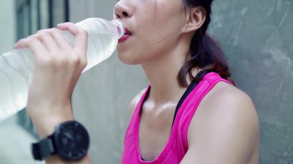 Young Asian drinking water because feel tiredt park. Lifestyle active women exercise in the city