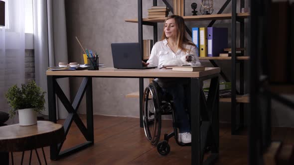 Concentrated Disabled Woman Working in Home Office