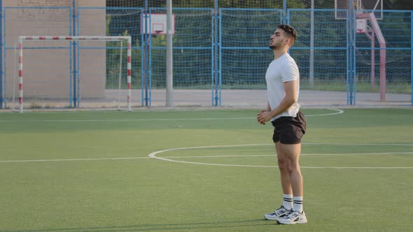 Young Energetic Athletic Hispanic Arab Guy in Summer Sportswear Shows Squat Technique