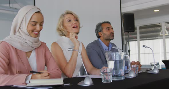 A panel of business delegates talking at a conference