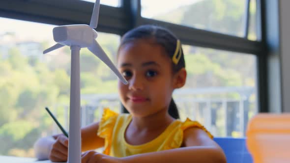 Mixed race schoolgirl studying at desk in classroom 4k