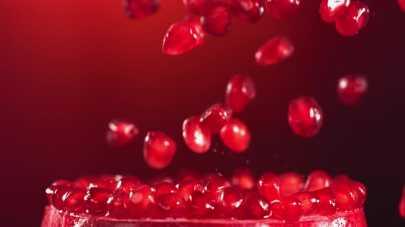 Pomegranate Grains Falling on Surface of Half Pomegranate in Slow Motion