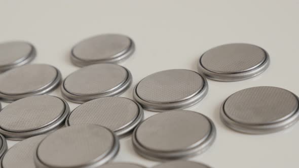 Lot of metallic button  batteries on white 4K panning footage