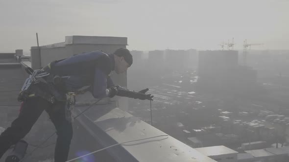 Сlose-up Shot of a European Male Professional Industrial Climber Standing on the Roof of a High