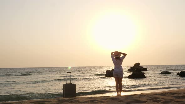 Silhouette of a Young Woman with Outstretched Arms at Sunrise, on the Beach By the Sea, Enjoying