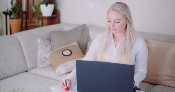 Businesswoman Working on Laptop on a Project at Home Office