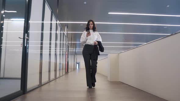 Confident Business Woman Uses a Mobile Phone