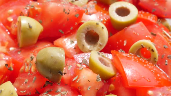 Olives and tomatoes appetizing salad in a glass bowl slow tilt 4K 2160p 30fps UltraHD footage - Slow