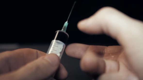 Slow Motion of Hand Getting a Hypodermic Syringe. Addict Preparing for Getting Drug Dose Injection