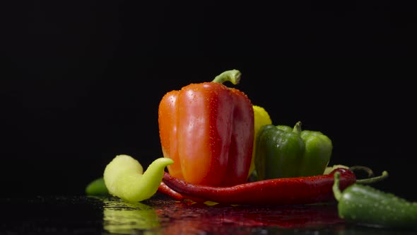 Peppers Wet with Drops of Moisture on Black Background