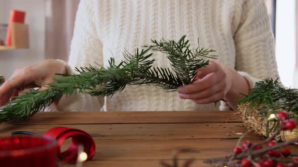 Happy Woman Making Fir Christmas Wreath at Home