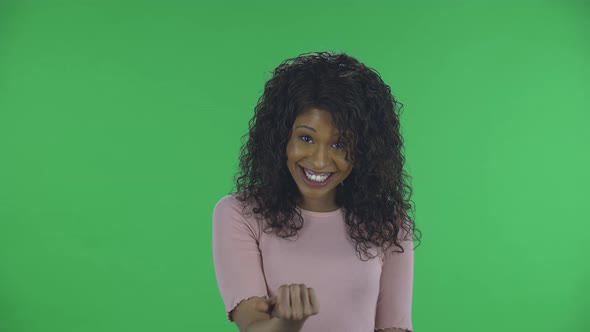 Portrait of Beautiful African American Young Woman Is Looking at Camera with Enthusiastically Waving