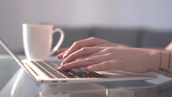 Woman Typing on Laptop Keyboard at Home