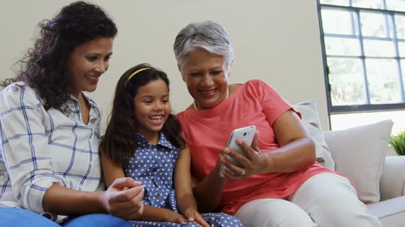 Girl with mother and grandmother smiling at mobile phone 4K 4k