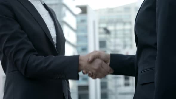 Side View of Businesswomen Shaking Hands on Street.