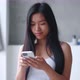 Attractive Young Asian Woman Using Smartphone While Standing in Bathtub at Home - VideoHive Item for Sale