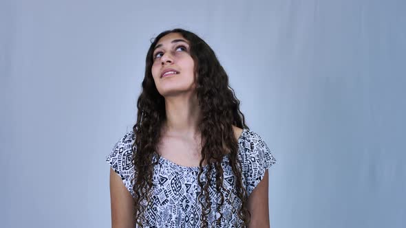 Teenage long haired girl looking upwards, isolated on white background