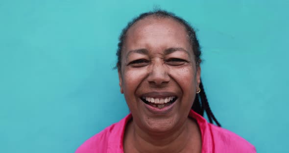 Senior african woman smiling on camera with blue background