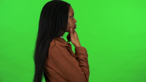 A Young Black Woman Walks Back and Forth and Thinks About Something - Green Screen Studio
